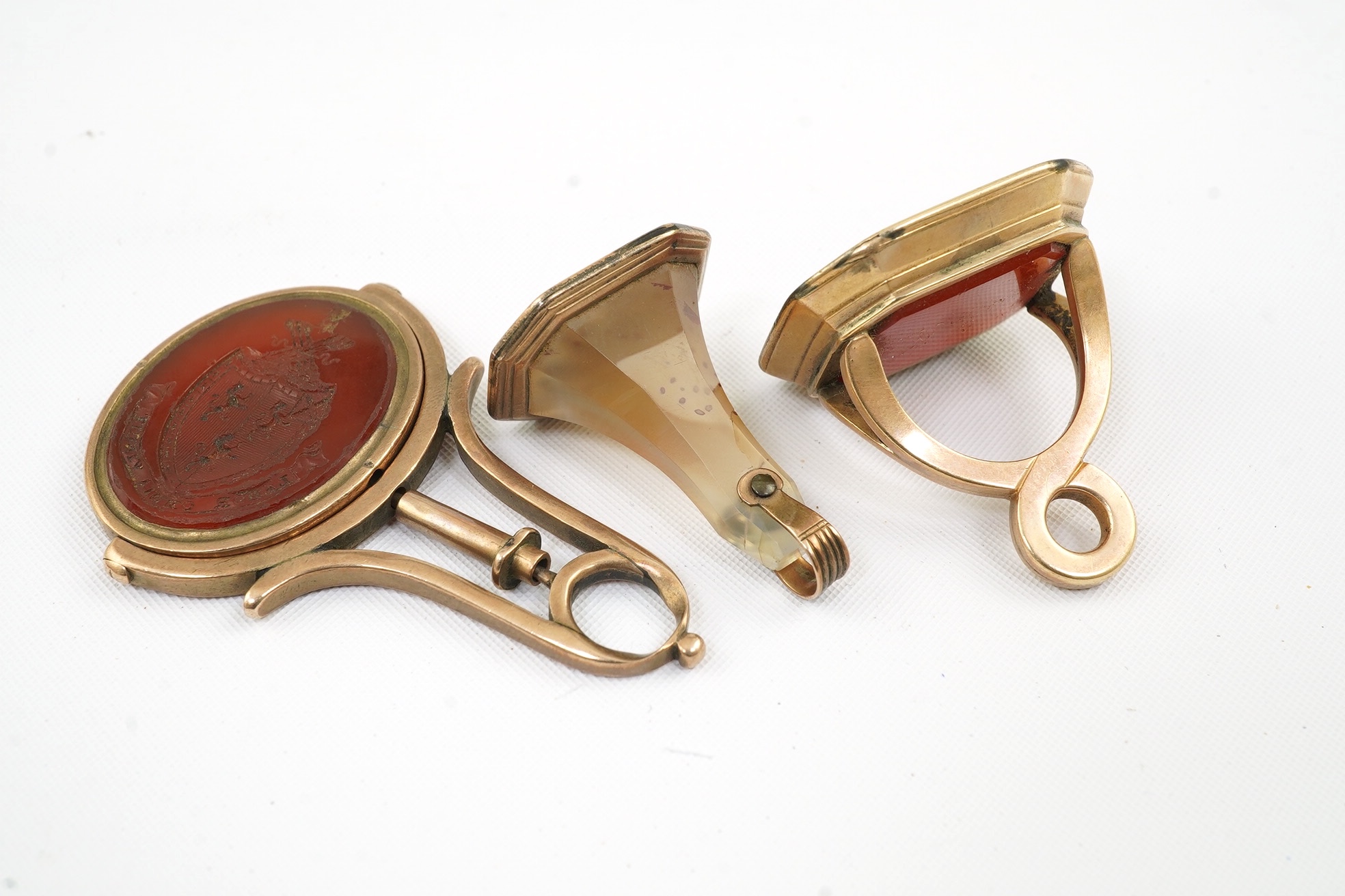 Two 19th century gold overlaid and carnelian set fob seals, both matrix carved with armorials, together with a similar gold and agate set fob seal